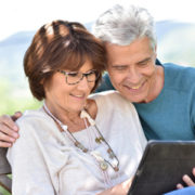 Senior couple using tablet in yard